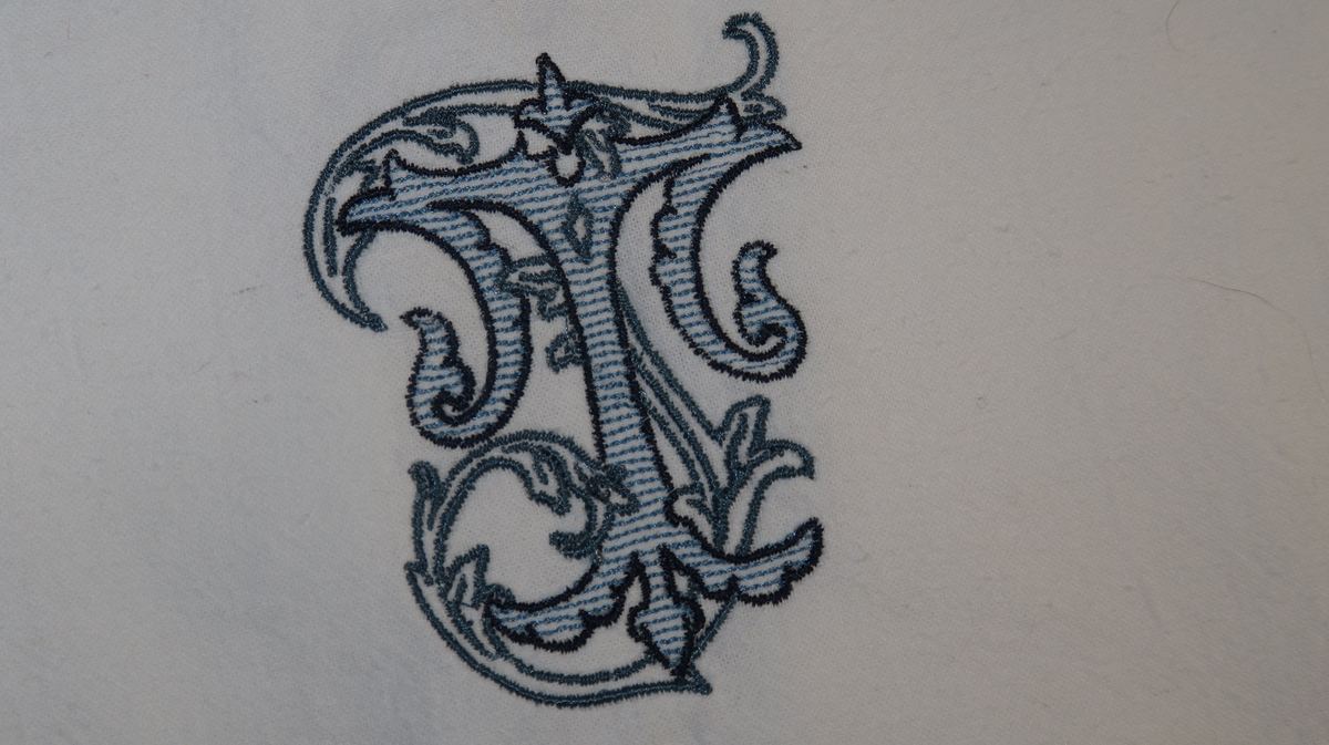 Close-up ornate monogram on white fabric